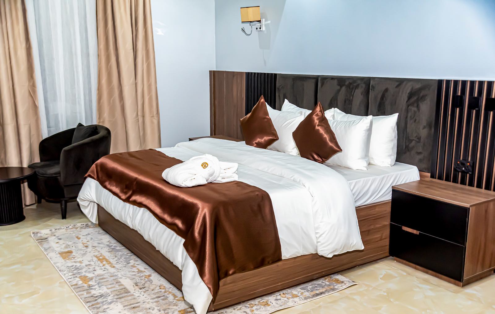 Arena Continental guest room with a king bed and warm wood finishes